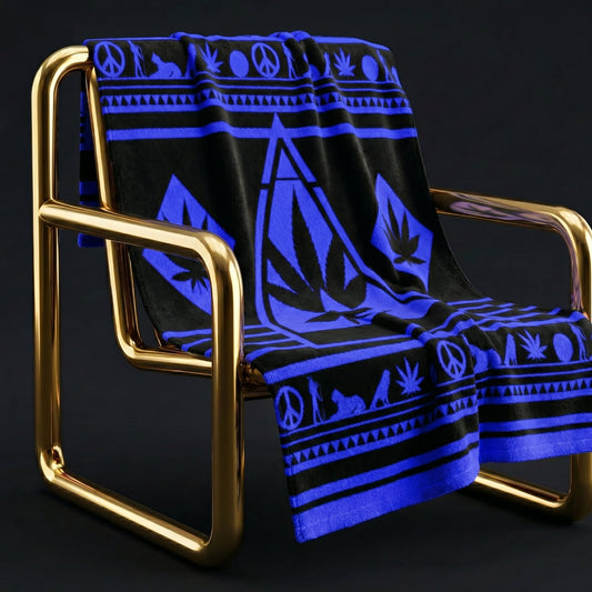 The Black and Electric Blue NGU Architect Towel draped over a modern gold-frame lounge chair. The image demonstrates the "Armor-Drape" physics of the 360gsm fabric, with the bold blue geometric manifesto design clearly visible against the sleek black material.
