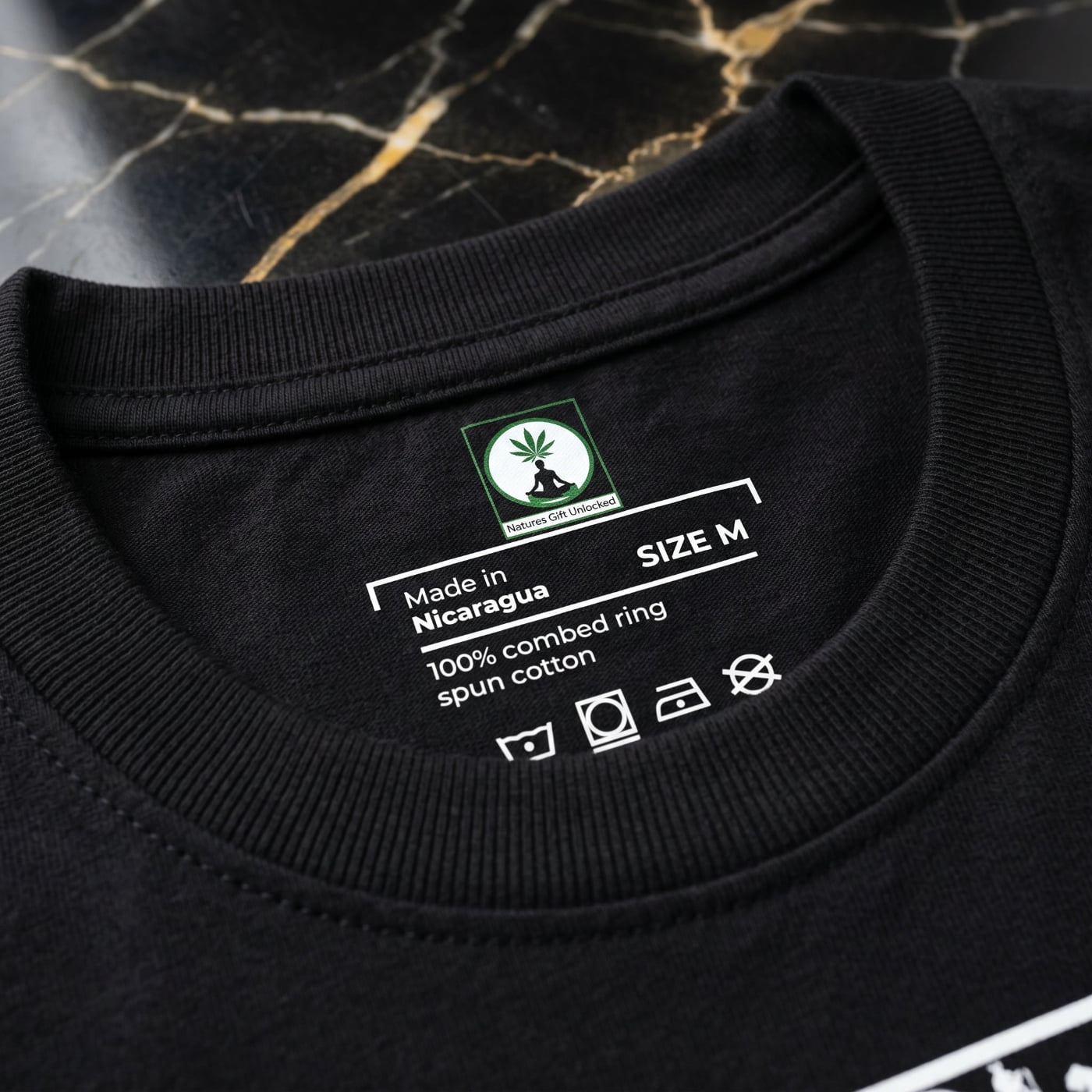 Forensic macro of NGU internal neck branding screen-printed in white ink on 400gsm matte-black cott