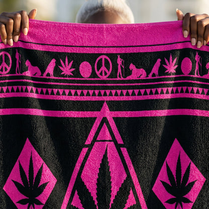 Sovereign Female Anchor on the beach holding the 36-inch wide NGU Sanctuary Towel taut, showcasing the large-scale pink geometric marijuana leaf design.