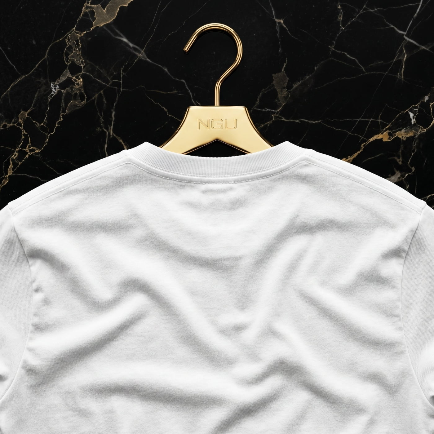 Rear view of the NGU white 400gsm t-shirt on a gold hanger showing the clean architectural drape and heavy matte-weave construction.