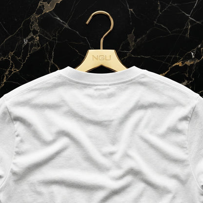 Rear view of the NGU white 400gsm t-shirt on a gold hanger showing the clean architectural drape and heavy matte-weave construction.